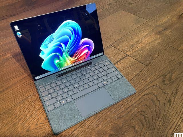 Microsoft Surface Pro tablet connected to detachable keyboard, sitting on wooden floor.