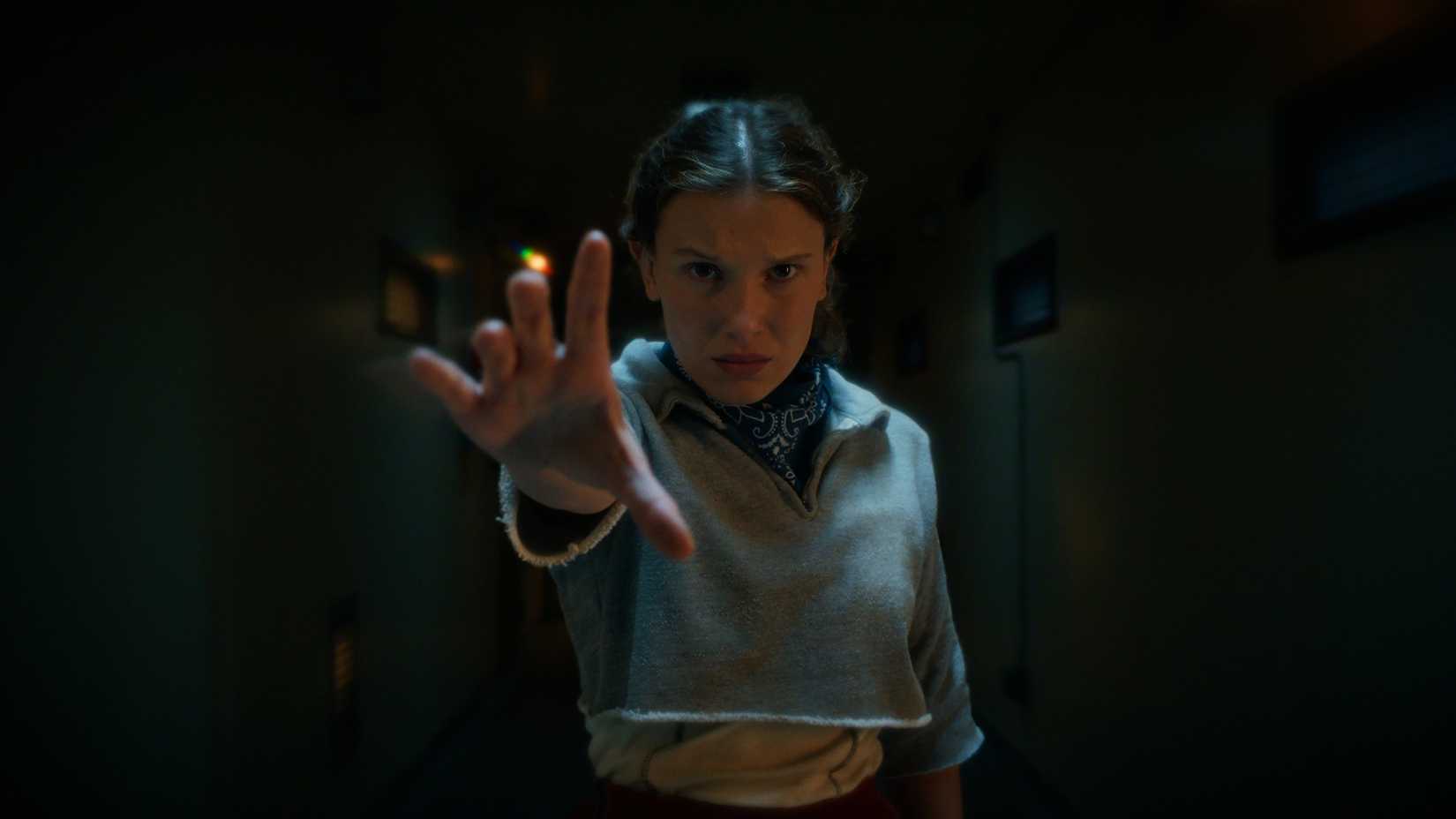Eleven (Millie Bobby Brown) dressed in workout clothes holds out her hand to use her powers in Stranger Things sesaon 5